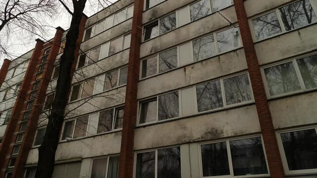 An old Soviet dormitory with large windows. The camera moves on a gimbal.