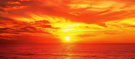 Obraz premium A vibrant red and yellow sunset over the horizon with a copy space image.