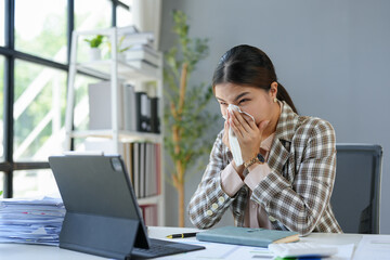 Asian businesswomen, tired, stressed office workers, headaches over delayed work hours. Body aches, discomfort, work not being accomplished according to the set goals. Office syndrome concept.