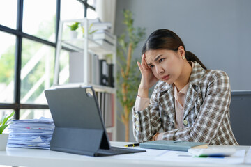 Asian businesswomen, tired, stressed office workers, headaches over delayed work hours. Body aches, discomfort, work not being accomplished according to the set goals. Office syndrome concept.
