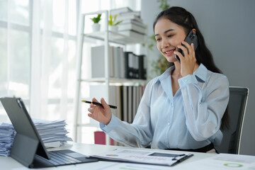 Attractive Asian businesswoman uses smartphone to communicate with customers online Finance staff make business calls on mobile phones Discuss working with clients.