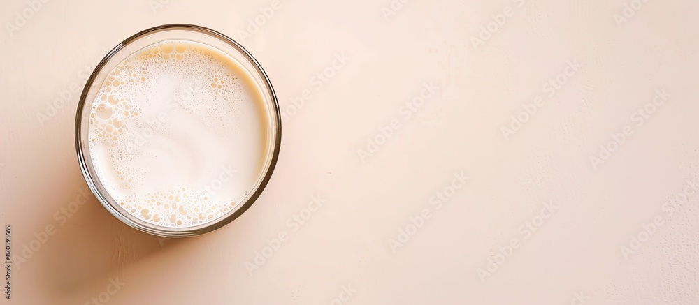 Aufkleber Almond-based alternative milk in an unpeeled glass placed on a white table viewed from above with copy space image.
