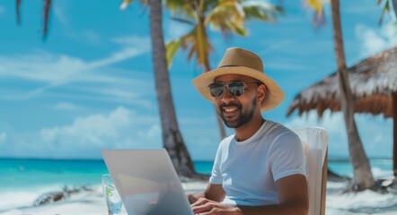 Young man working with laptop computer on the beach