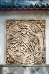 A detailed stone carving decorating a wall in China