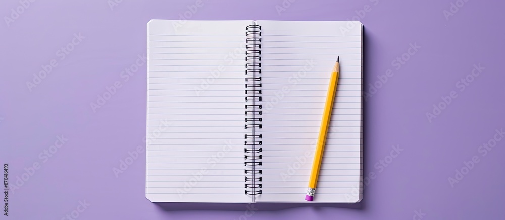 Poster a notebook and pencil displayed on a violet surface, showcasing an open spiral notepad on a table. t