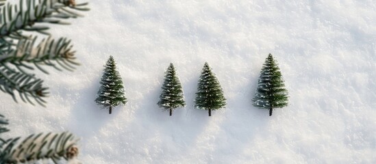 Obraz premium Top-down view of three Christmas trees sketched in the snow on a white surface, in natural daylight with a side angle, creating a winter holiday theme with a copy space image.
