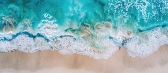 Naklejka premium Capturing a stunning aerial image of a pristine tropical beach with foamy waves and crystal-clear waters, a perfect backdrop for summer vacation, featuring ample copy space.