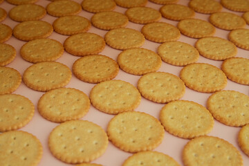 Crackers spread on pink background closeup, cookies on pink background, appetizing cookies on pink table surface,