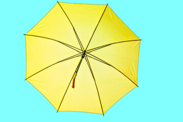 Open yellow umbrella on turquoise background