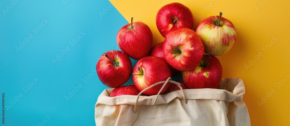 Poster juicy red apples overflow from the grocery bag against a colorful yellow-blue backdrop, creating an 