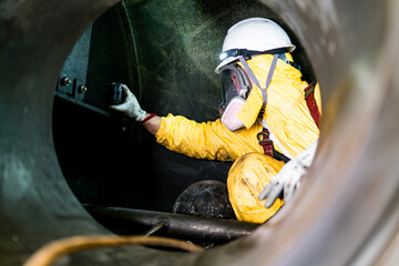 Employees inspect by taking photographs of internal pressure tanks in confined spaces.