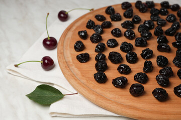 Wooden plate with cherry berries on light the table closeup. Side view, Space for text.