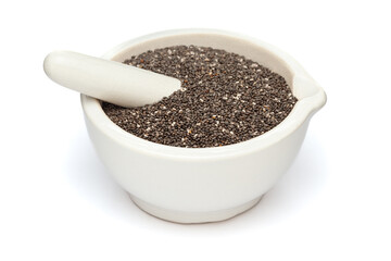 Close-up of Dry Organic Chia Seeds (salvia hispanica), in white ceramic mortar and pestle, isolated on a white background.