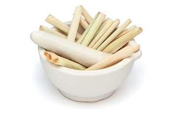 Close-up of Dry Organic lemongrass (Cymbopogon flexuosus), in white ceramic mortar and pestle, isolated on a white background.