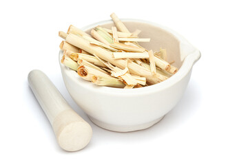 Close-up of Dry Organic lemongrass (Cymbopogon flexuosus), in white ceramic mortar and pestle, isolated on a white background.