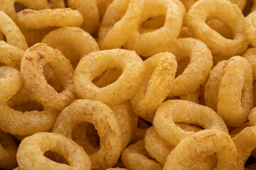 Crispy ring snacks isolated on white background. Corn onion rings in bowl isolated on white background. Crispy onion rings, isolated on white background. Snacks for watching movies.