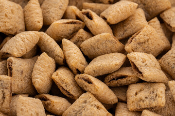 Corn snack. Cereal pads with filling falling into bowl against white background