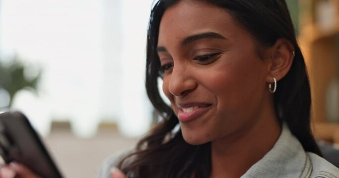 Indian woman, online and smartphone on sofa for reading, scroll and flirt on phone in home. Female person, network and mobile app for creating profile, chat and message with match on dating website