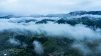 Aerial view of the beautiful Sapan village scenery, a small village in the middle of a valley surrounded by nature during the rainy season.