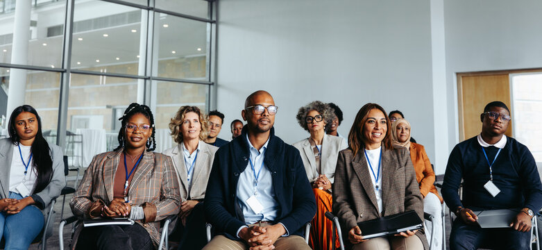 Diverse group of professionals attending a work conference in a modern office setting
