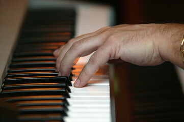 Man playing the piano. Detail on the hand.