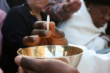 Priest giving holy communion to a faithful. Paris. France.
