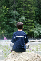 Teenager meditating and praying in nature.