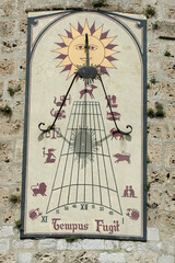 Old sundial on the wall of a house.. France.
