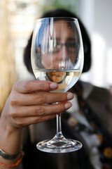 Woman drinking a glass of white wine alone.