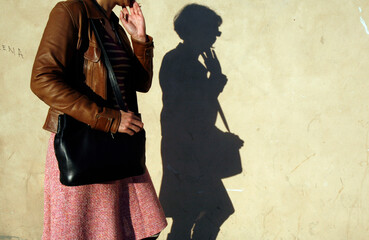 Woman and her shadow on a wall. Bipolarity. Italy.