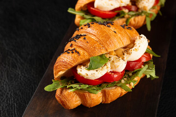 Italian food snack. Fresh croissant caprese, mozzarella, arugula and tomatoes