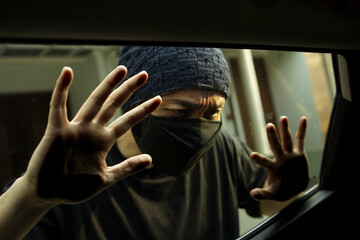 Criminal Thief With A Black Mask Looking Through A Car Window To Search For Things To Steal