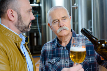 brewer manager and owner tasting beer at the brewery