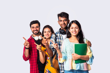 Indian asian college student against white pointing or advertising at blank copy space