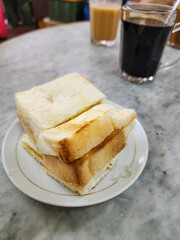 Kaya toast butter and black coffee. Traditional oriental and vintage kopitiam breakfast style. Popular in Malaysian and Singaporean.