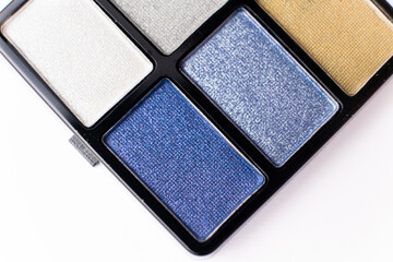 Glitter eye shadow palette on white background close-up.