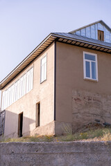 A brown building with a white roof and windows