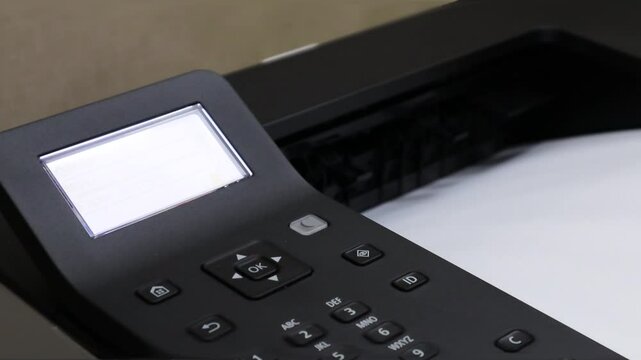 An office printer working and printing smoothly while ejecting paper after printing