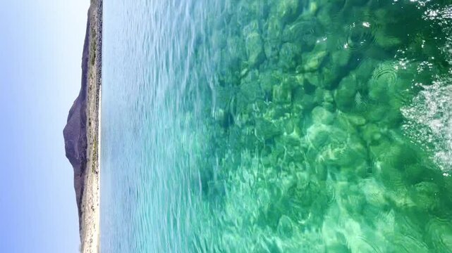 Vertical video Sailing thru the sea of Cortez looking at Coronado Island, beautiful clear turquoise water