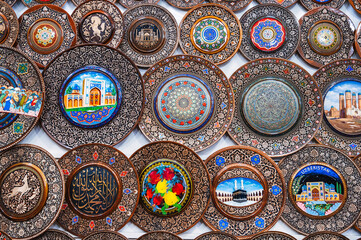 Uzbek wooden handmade gift plates with wood carvings hand-painted in the souvenir shop of Uzbekistan in Tashkent