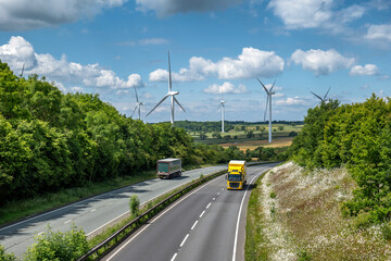 two lorry trucks moving at speed on UK motorway in England at sunset