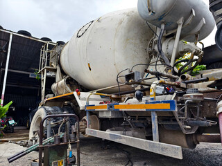 A concrete mixer truck parked beside of a concrete factory