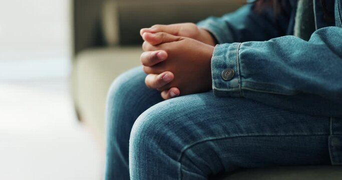 Hands, nervous and person on sofa in counselling for mental health, help and psychology rehabilitation of trauma. Closeup, anxiety and diagnosis in therapy in fear, stress and worry or overwhelmed