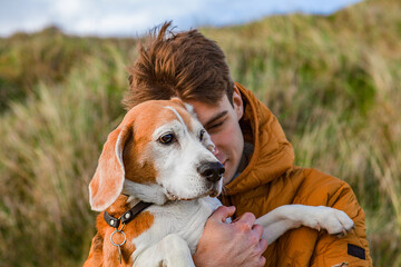 Boy is hugging a dog