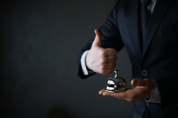 Portrait of Businessman in Black Suit Holding silver Bell. Ring for Service Concept.