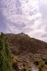 A mountain with a cloudy sky in the background