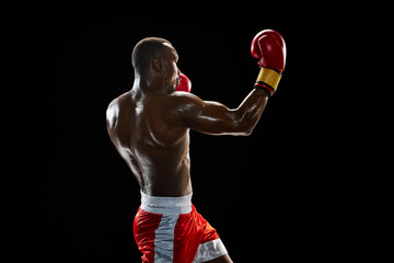Uppercut punch. Determined man, athletic boxer with strong body, punching, fighting isolated on...