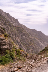 A rocky mountain range with a cloudy sky in the background