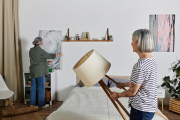 A mature lesbian couple decorates their modern apartment together.