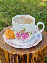 Coffee with milk and profiteroles on a wooden background